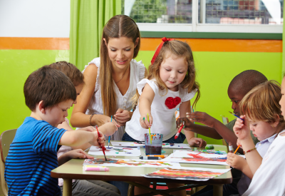 Bambini pitturare con l'educatore / l'educatrice