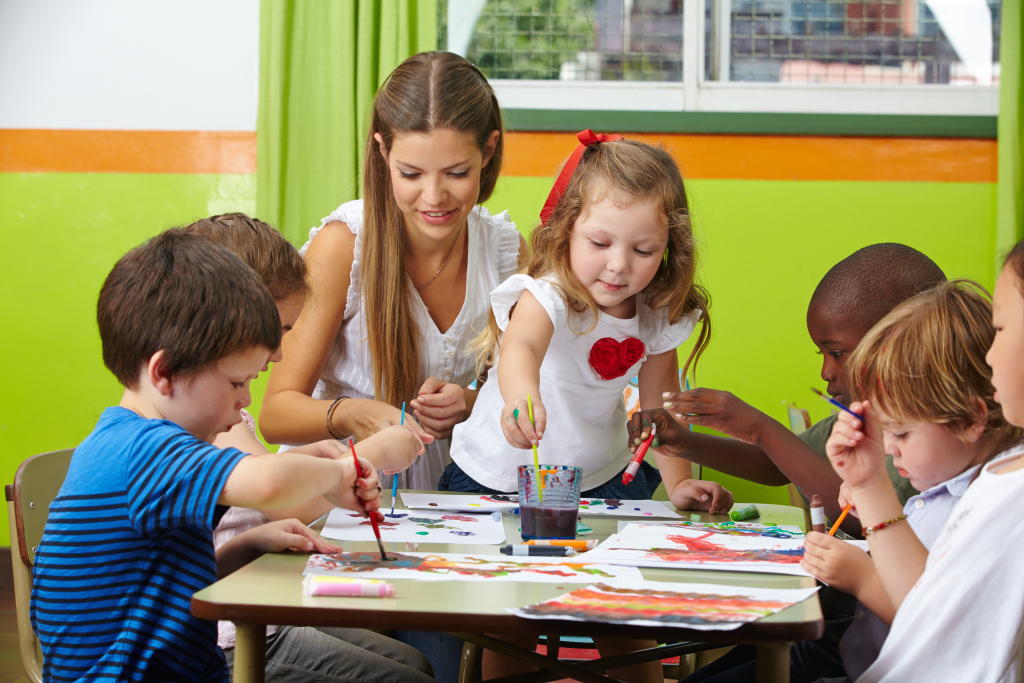 Bambini pitturare con l'educatore / l'educatrice